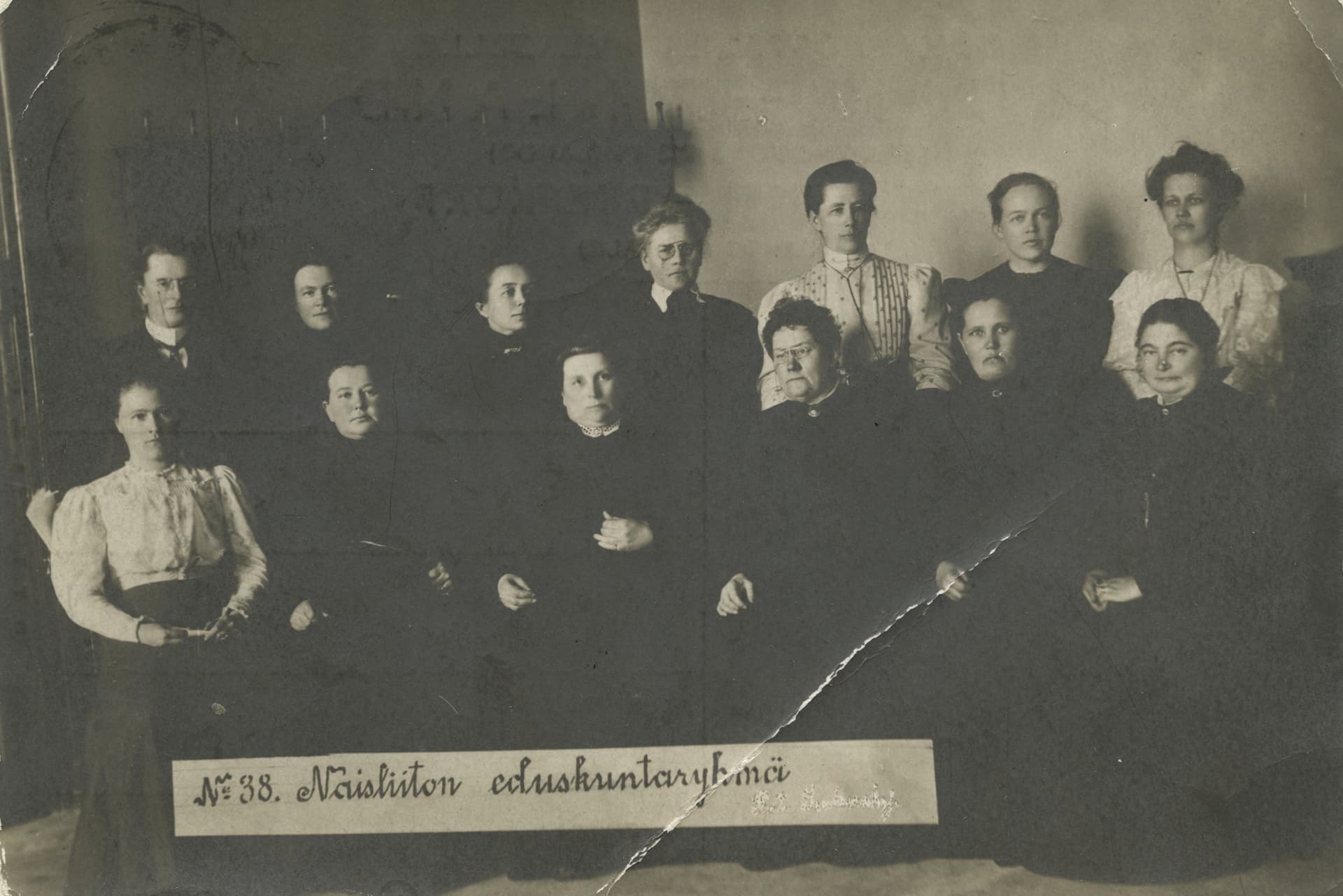 Mustavalkoinen kuva, jossa on vuonna 1907 valituista naiskansanedustajista 13. He istuvat kahdessa rivissä.