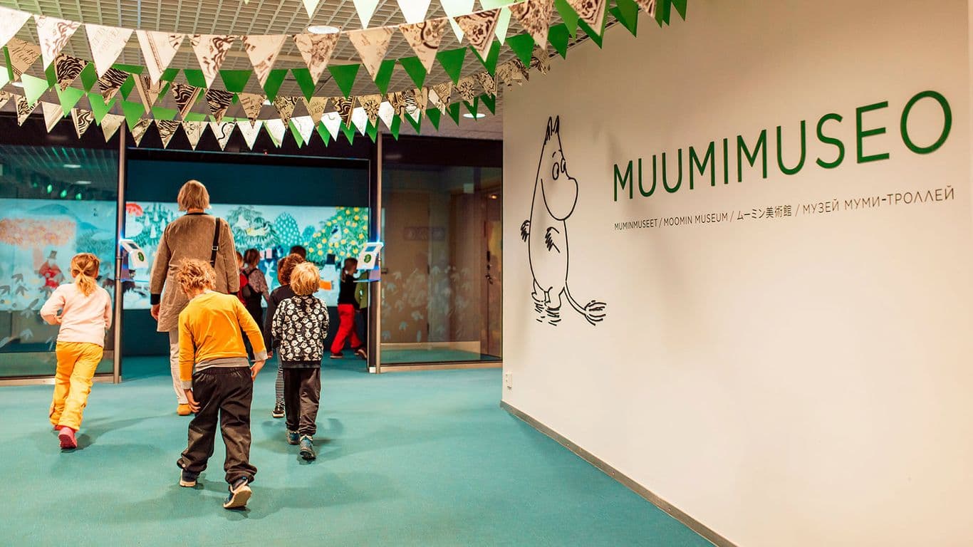 Perhe kävelemässä Muumimuseon sisäänkäynnille.