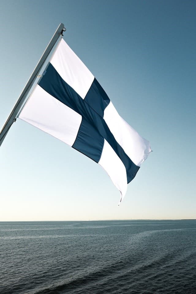 Suomen lippu veneen perässä veden päällä